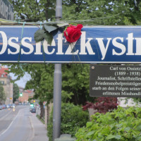 Ossietzkystraße - Straßenschild mit Rose zum Gedenken
